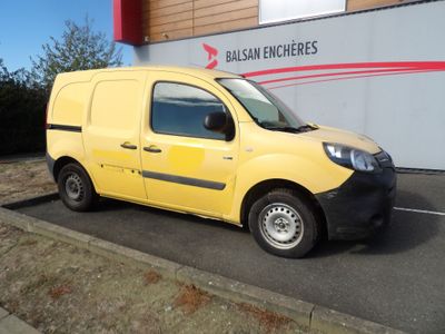 une petite camionnette jaune garée devant un immeuble