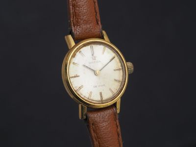 une photo d'une montre-bracelet plaquée or avec un bracelet en cuir marron