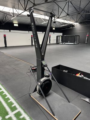an empty indoor gym with a football field and a football goal