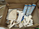 a cardboard box filled with plumbing supplies and a hose