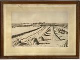 une vieille photo d'une ferme avec une rangée de foin au premier plan
