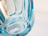 a blue glass vase with a label on it