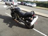 a black motorcycle parked in a parking lot next to some cars