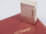 a silver lighter sitting on top of a red book