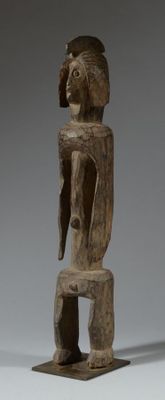 une vieille statue en bois d'un homme avec un chapeau sur la tête