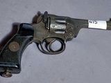 un pistolet muni d'une étiquette, posé sur une table