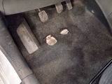 a car floor with a car pedals and a car floor mat