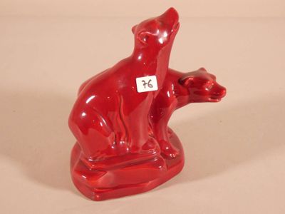 a red bear figurine sitting on a white surface