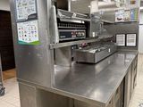 stainless steel counter top in a commercial kitchen with menus hanging from the ceiling