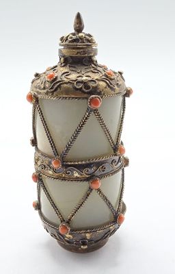 une image représentant un vase blanc surmonté de perles orange