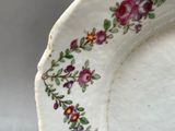 a close up of a plate with flowers painted on it