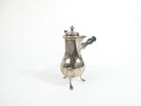 a silver coffee pot with a handle on a stand