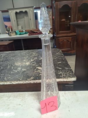une bouteille en verre sur laquelle est collé un autocollant rose