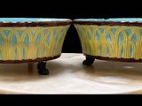 deux vases bleus et jaunes posés sur un socle en marbre