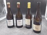 quatre bouteilles de vin sont alignées sur une table