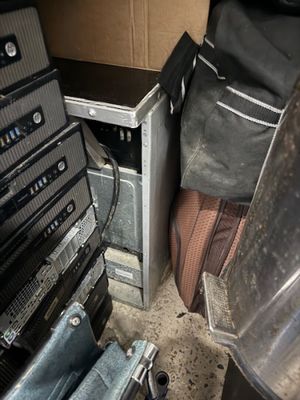 a pile of electronics and a suitcase in a room