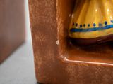 une figurine en céramique représentant une femme en robe jaune