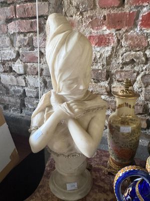une statue représentant une femme portant un foulard sur la tête