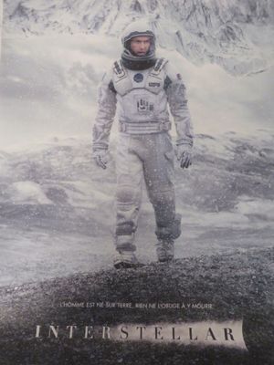 affiche représentant un homme en combinaison spatiale debout devant une montagne enneigée