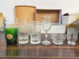 des bouteilles et des verres posés sur une table, avec des boîtes et une bougie