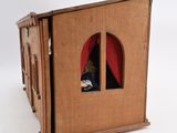 a cardboard doll house with a doll inside of it
