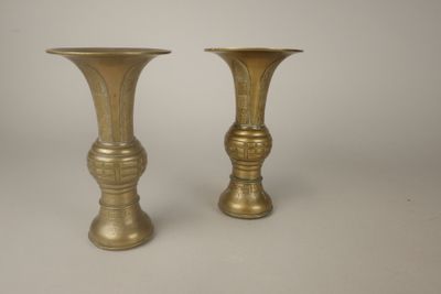 une paire de vases anciens en laiton sur fond blanc