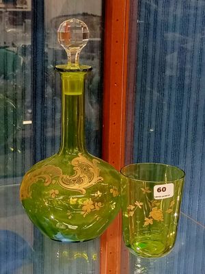 two green glass vases on display in a glass case