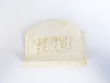 a small carving of a group of people on a white surface