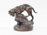 statue représentant un chien et un chat posés sur un rocher, sur fond blanc