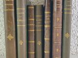 cinq vieux livres sont alignés sur une table