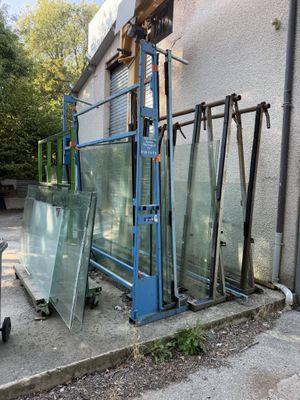 many pieces of glass sitting on the ground outside of a building