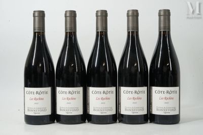 six bouteilles de vin rouge sont alignées sur une surface blanche