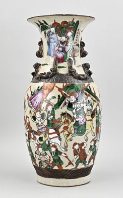 un vase avec un tableau posé sur une table