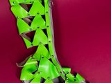 neon green high heeled sandals with studded straps on a red background