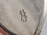 a close up of a silver plate with a monogram on it