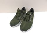 a pair of green running shoes on a white surface