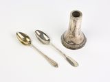 deux cuillères en argent et une tasse en argent posées sur une table