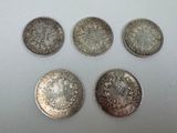 six different types of silver coins on a white surface