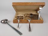 des couverts dans un coffret en bois, avec des cuillères et un repose-cuillère posés sur une table