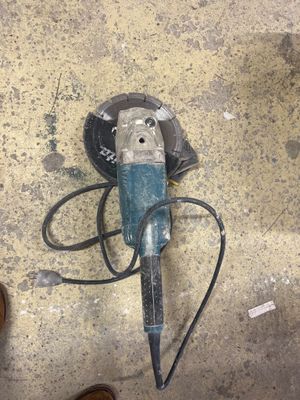 une petite machine posée par terre à côté d'une paire de chaussures