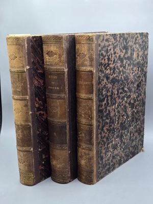 trois vieux livres sont empilés sur une table