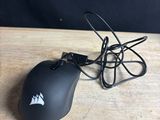a black mouse on a wooden table with a black background