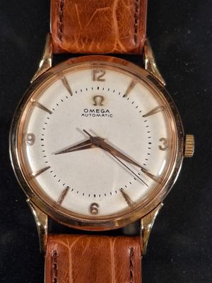 an image of a close up of a wrist watch on a black surface