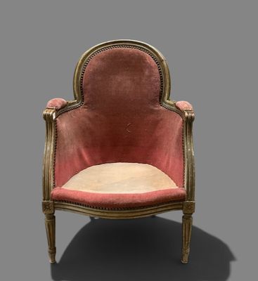 une chaise rose avec des finitions dorées et un coussin beige
