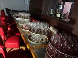 many empty wine glasses lined up on a long table