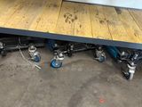 une table en bois munie de roulettes, dans un garage