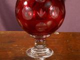 a red glass ball sitting on top of a wooden table