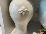 two vases sitting on a shelf next to each other