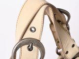 beige leather handbag with metal buckles on a white background