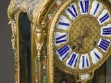 a gold clock with blue and white decorations on it